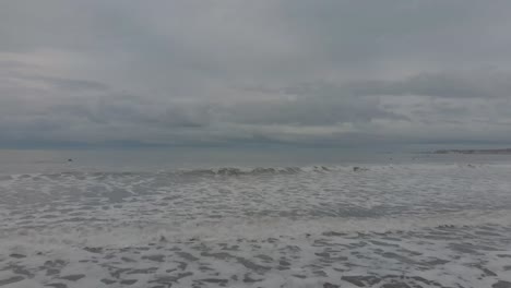 crashing ocean waves under overcast sky in nantasket beach, hull, massachusetts, usa during foggy day