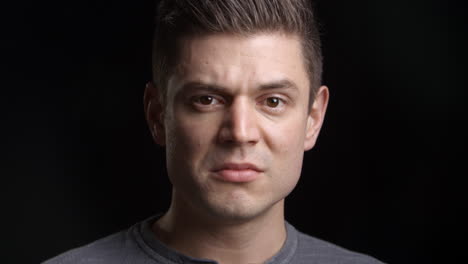 Studio-Shot-Of-Tearful-Man-Against-Black-Background