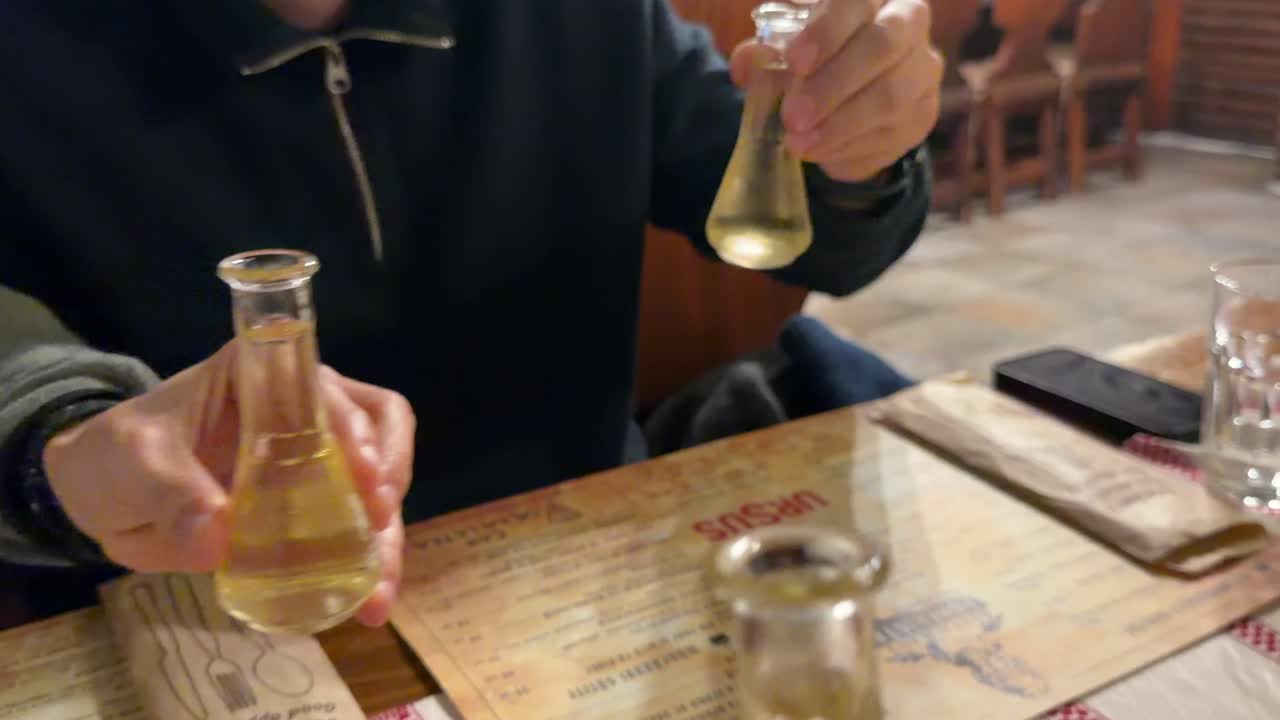 따뜻한 축하 토스트를 위해 손으로 병을 들어 올리는 클로즈업 뷰