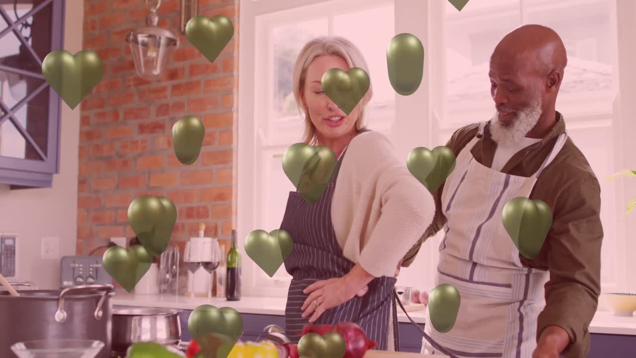 animación de corazones verdes sobre pareja enamorada cocinando en la cocina.