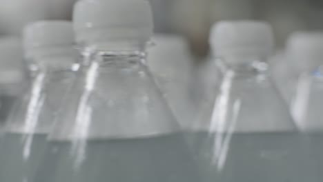 cinta transportadora con botellas de agua potable en una planta de bebidas moderna