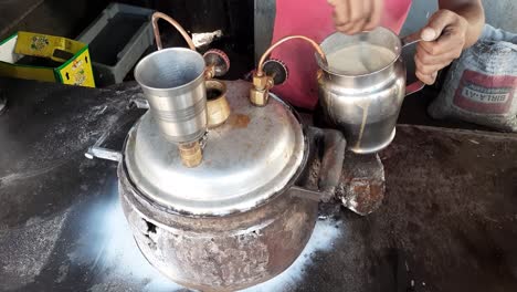 shopkeeper making hot delicious indian tandoori tea or tandoori chai at his tea stall