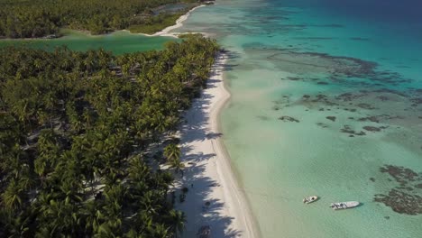 Toma-Aérea-De-Drones-De-Una-Playa-Tropical-Y-Una-Laguna-Con-Largas-Sombras-De-Palmeras-De-Coco