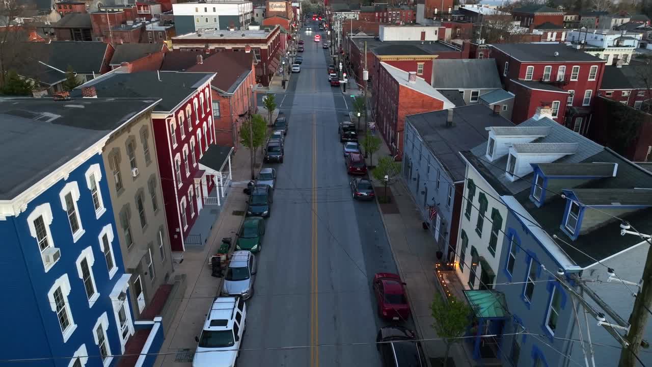 Aerial establishing shot of Main Street in Small Town America with Colonial Homes in the evening - reverse dolly, tilt up shot