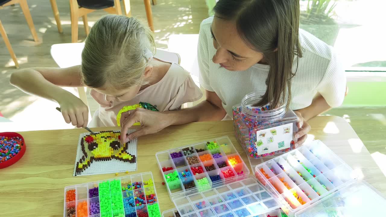 madre e hija participando en una actividad de artesanía de pixel art