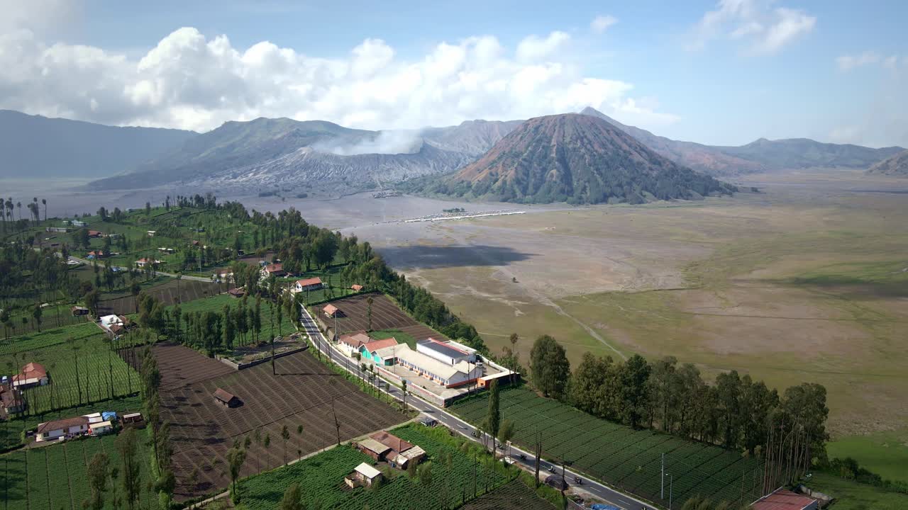 el encanto de una aldea en la ladera cerca del monte bromo contra el telón de fondo escarpado del icónico volcán activo y el valle del monte.