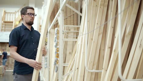 man shopping for lumber at a home improvement store