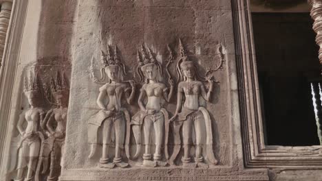 three women carved into a wall inside the temple angkor wat. 4k