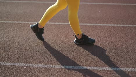 woman jogging on outdoor track in sportswear at athletic field