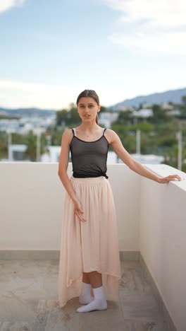 teenage ballerina posing on a balcony