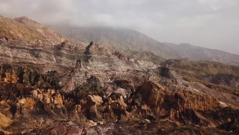 Capas-De-Paleta-De-Colores-De-Lujo-En-La-Naturaleza-Montaña-Mineral-De-Sal-En-Irán-Atracción-Natural-Caminatas-En-El-Desierto-Clima-De-Montaña-En-Verano-Pico-Nubes-Fondo-De-Niebla-Día-Brumoso-Horizonte-Vista-Aérea-Panorámica