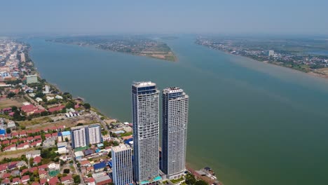skyline condominium complex residential buildings on mekong river, phnom penh city, drone shot