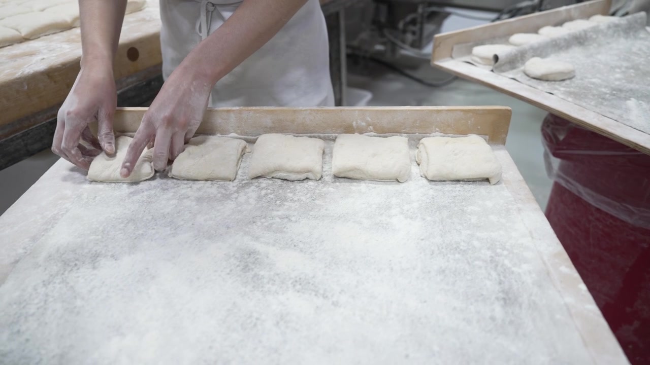 A woman preparing dough in a private bakery, captured in 4K resolution at 60fps, slow motion.