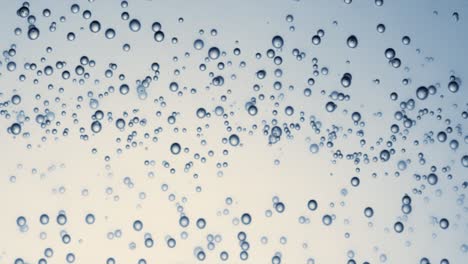 many water bubbles in blue water close up, abstract water wave with bubbles in slow motion.