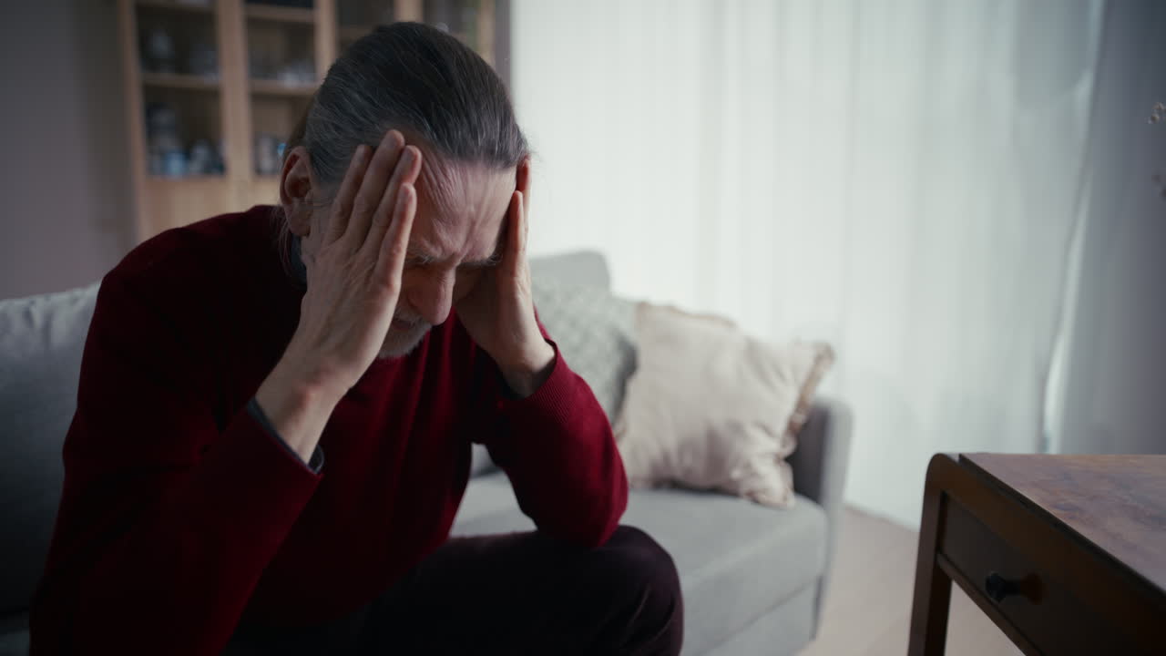 Elderly Man Suffering from Headache or Stress at Home