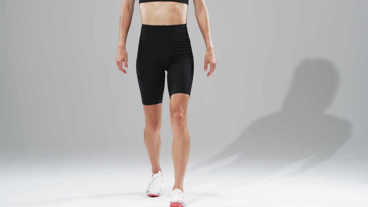 Focused athlete prepares for sprint in studio, highlighting determination.