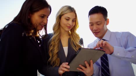 multi ethnic business team using touchscreen on rooftop