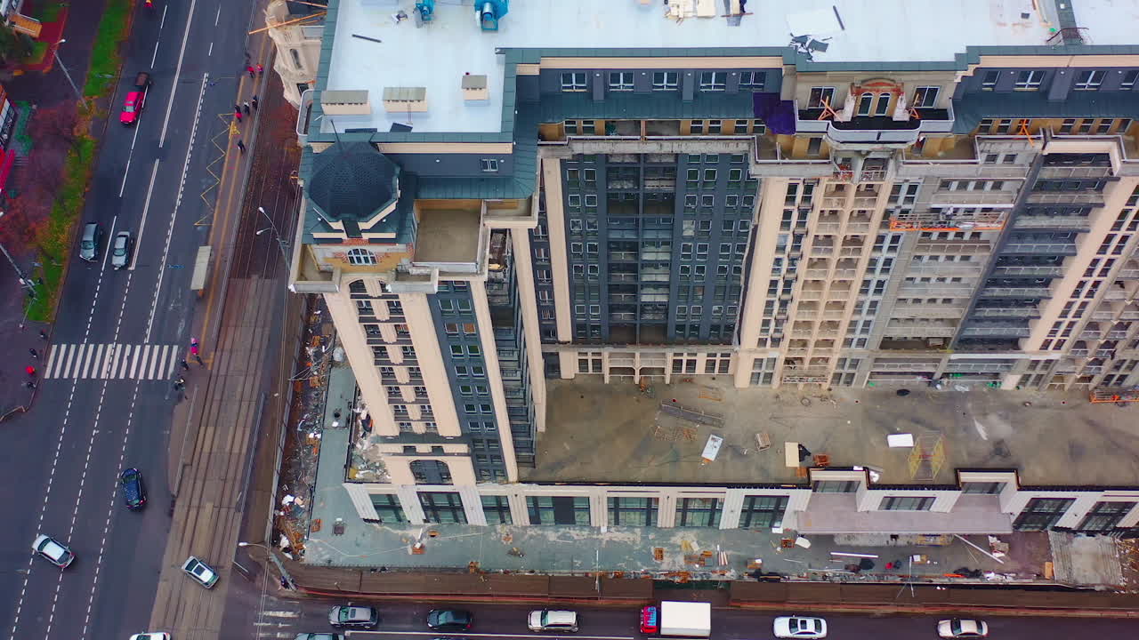 Building of multi-storey architecture. Modern tall apartment building under construction in the city. Aerial view.