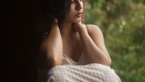 young beautiful woman adjusting hair in a rustic setting, gentle and intimate moment captured in natural light