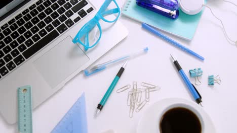 laptop, spectacles, pen, coffee, paper clip, scale, set square and headphones on white background 4k