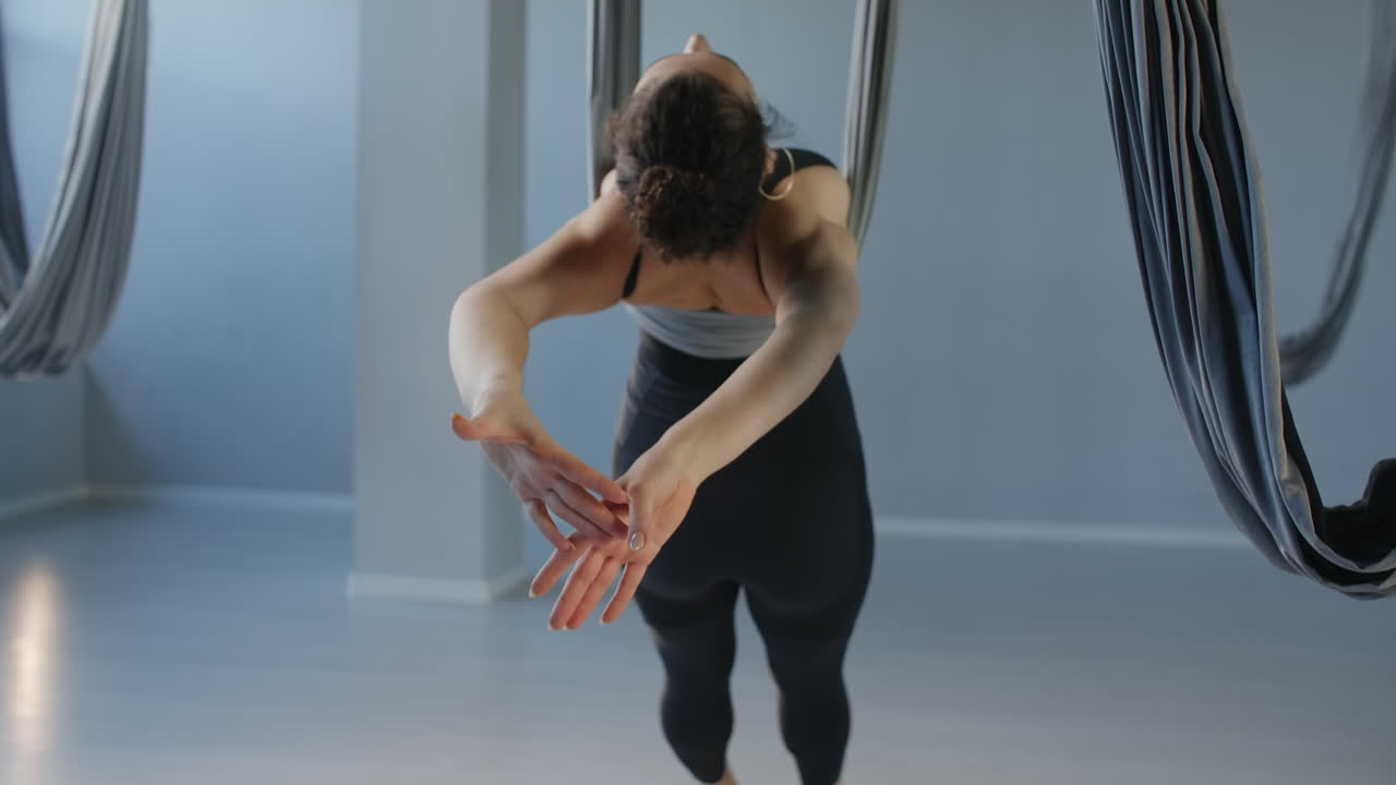 mujer practicando yoga aéreo