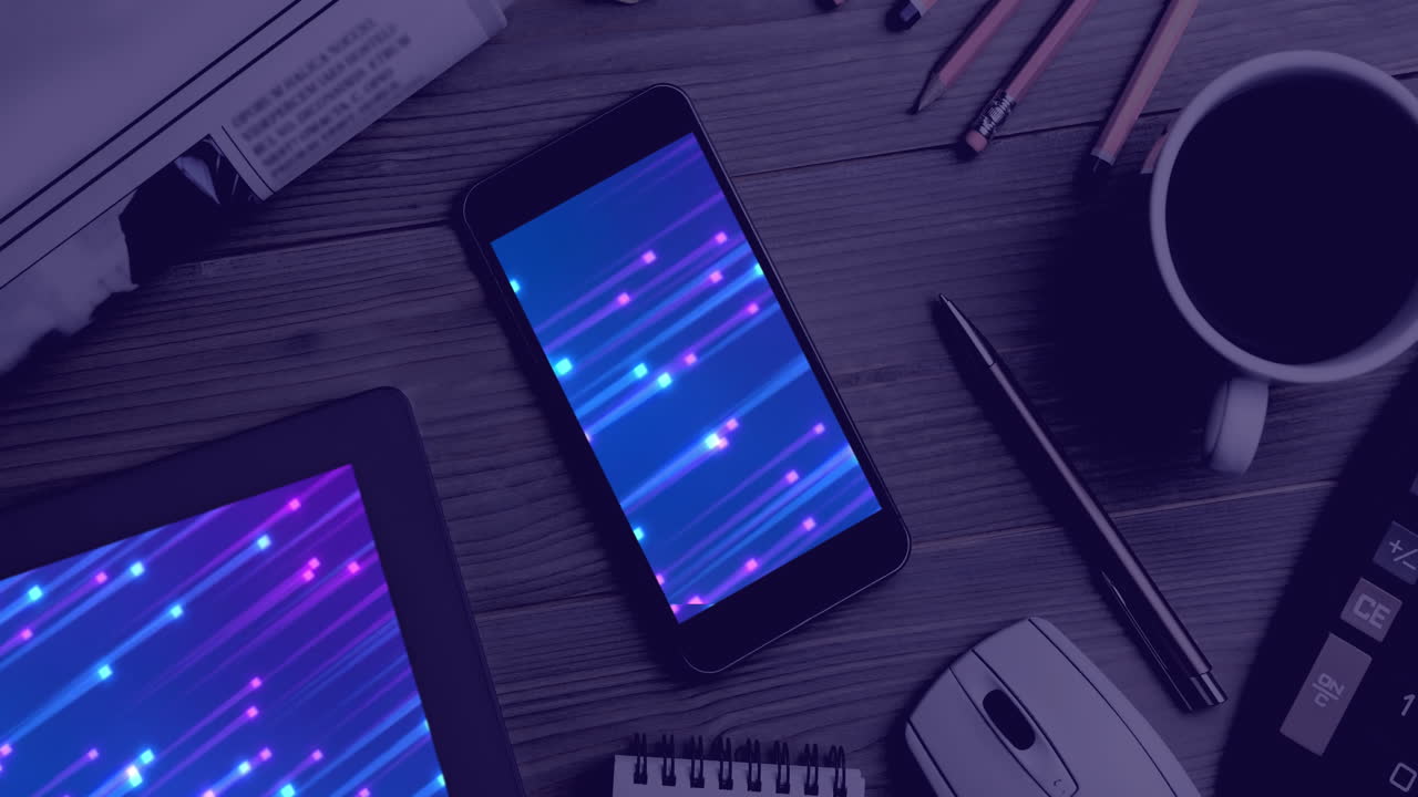 Animation of technological devices with light trails on screen on desk