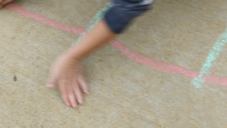 Young-boy-age-4-years-old,-drawing-on-sidewalk-with-chalk