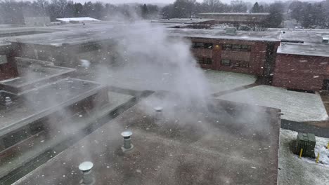 slow flurries flying while steam comes out of american high school building