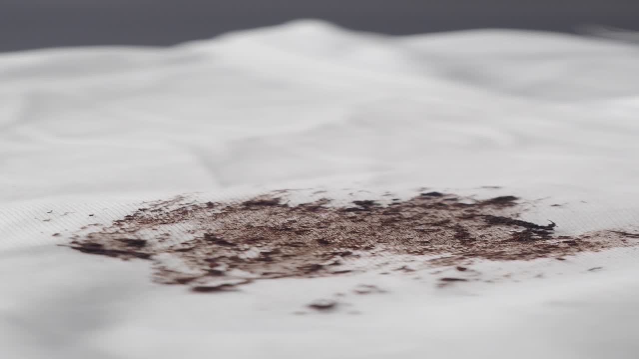 крупный план коричневого пятна на белой ткани