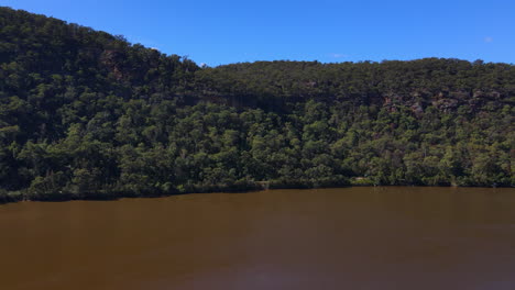 Toma-De-Drones-De-Un-Gran-Río-Marrón-Con-Colinas,-árboles-Y-Arbustos,-Hawkesbury,-Nueva-Gales-Del-Sur