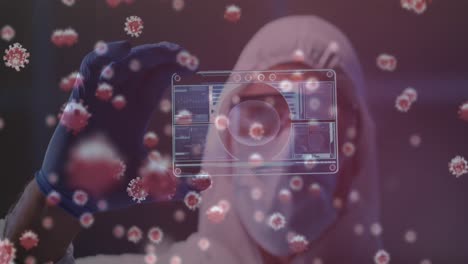 animación de células de covid 19 sobre el científico en traje de ppe sosteniendo la pantalla con procesamiento de datos médicos