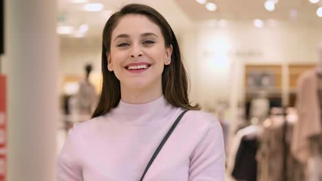 mujer sonriente con bolsas de compras llenas en un centro comercial