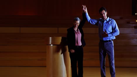 female business executive appreciating a colleague on stage