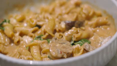 delicious italian mushroom and mascarpone creamy pasta with spinach in a bowl. european cuisine.