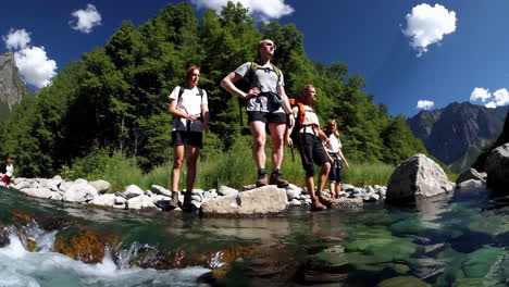 group hiking across a mountain river