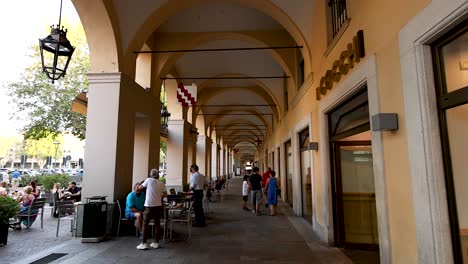 people walking under archways in piedmont, italy