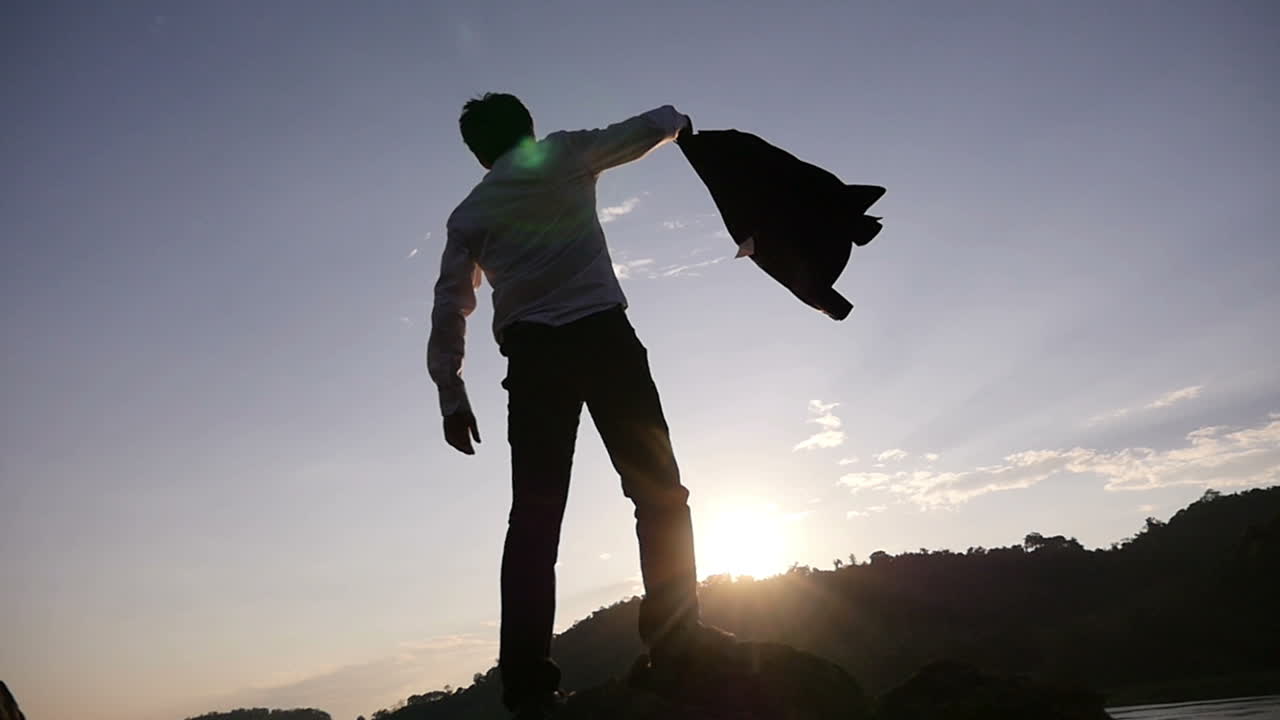 Businessman celebrating success at sunrise