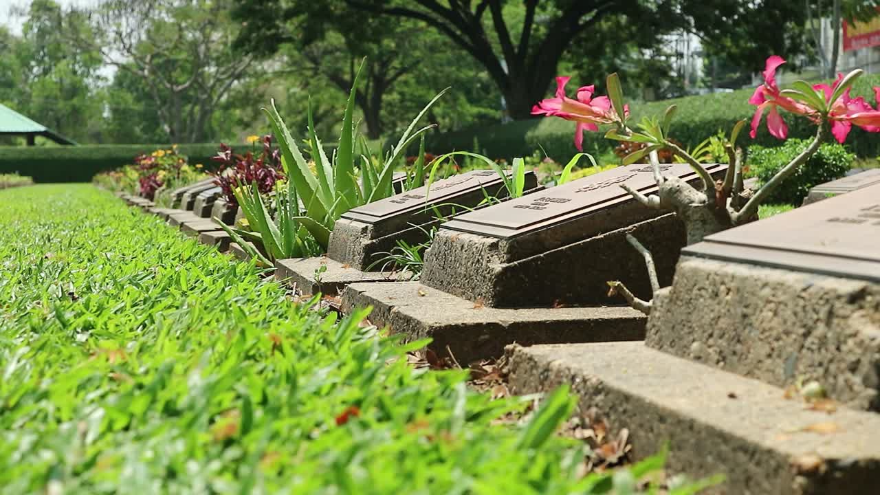 toma estática hd del cementerio conmemorativo de la segunda guerra mundial con lápidas de prisioneros de guerra en un cementerio pacífico en kanchanaburi, tailandia