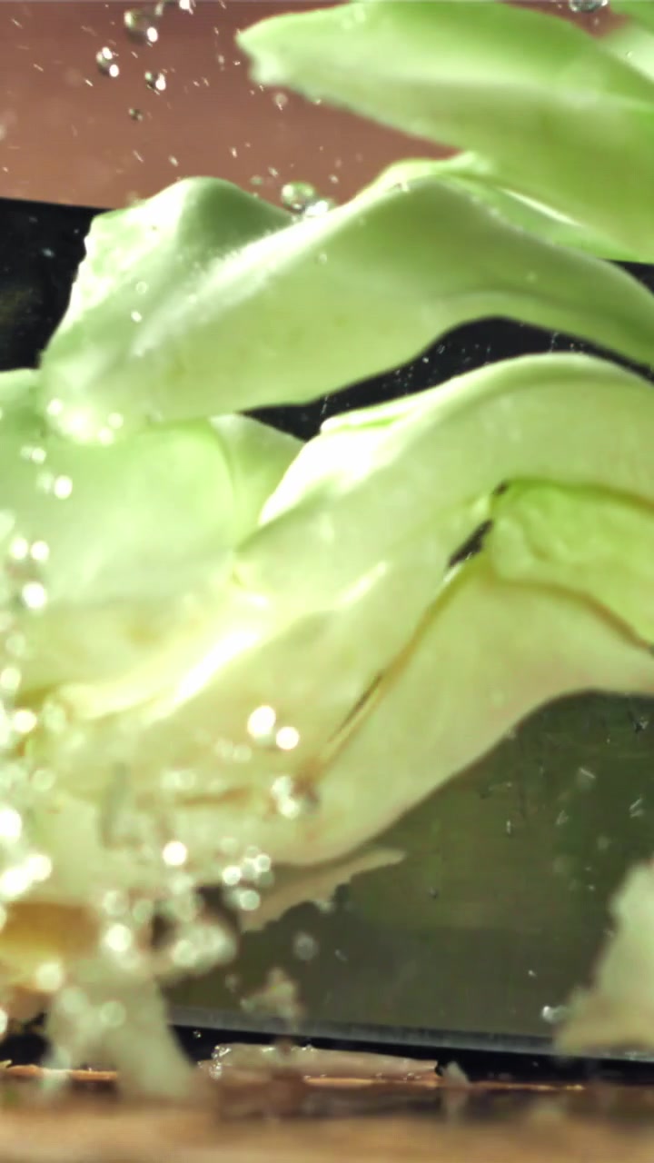 Close-Up of a Knife Slicing Through Fresh Cabbage in Slow Motion
