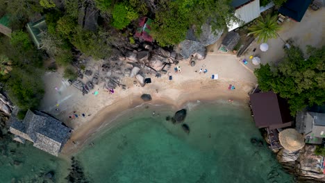 people relaxing on stunning tropical beach - aerial overhead drone shot