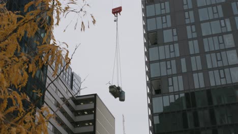 construction crane hook block and cable lifting piles of debris at the building site