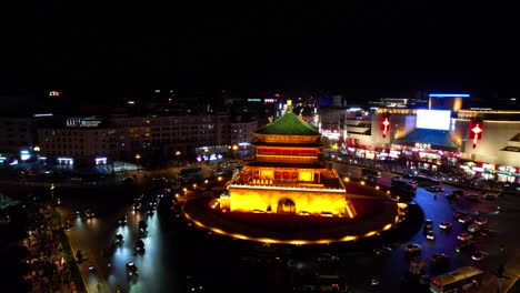 bell tower in xi'an illuminated at night surrounded by busy traffic and city lights, china