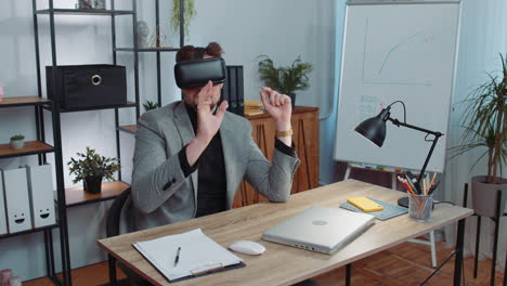 Businessman-working-using-virtual-reality-futuristic-technology-VR-app-headset-helmet-at-home-office