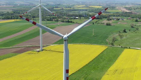 Closeup-reverse-dolly-away-from-center-of-windmill-turbine-blades-in-countryside