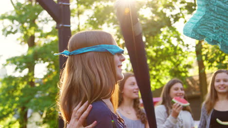 mother turns blindfolded daughter who then hits pinata