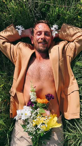 man relaxing in grass with flowers