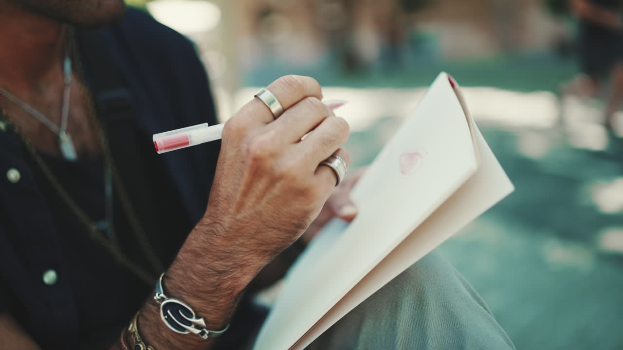 Person drawing in a notebook with a pen
