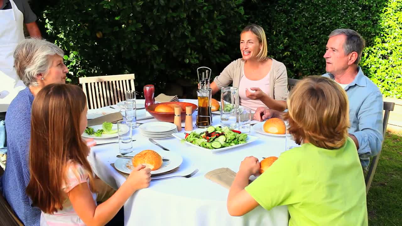 Forældre snakker med bedstemor under måltidet