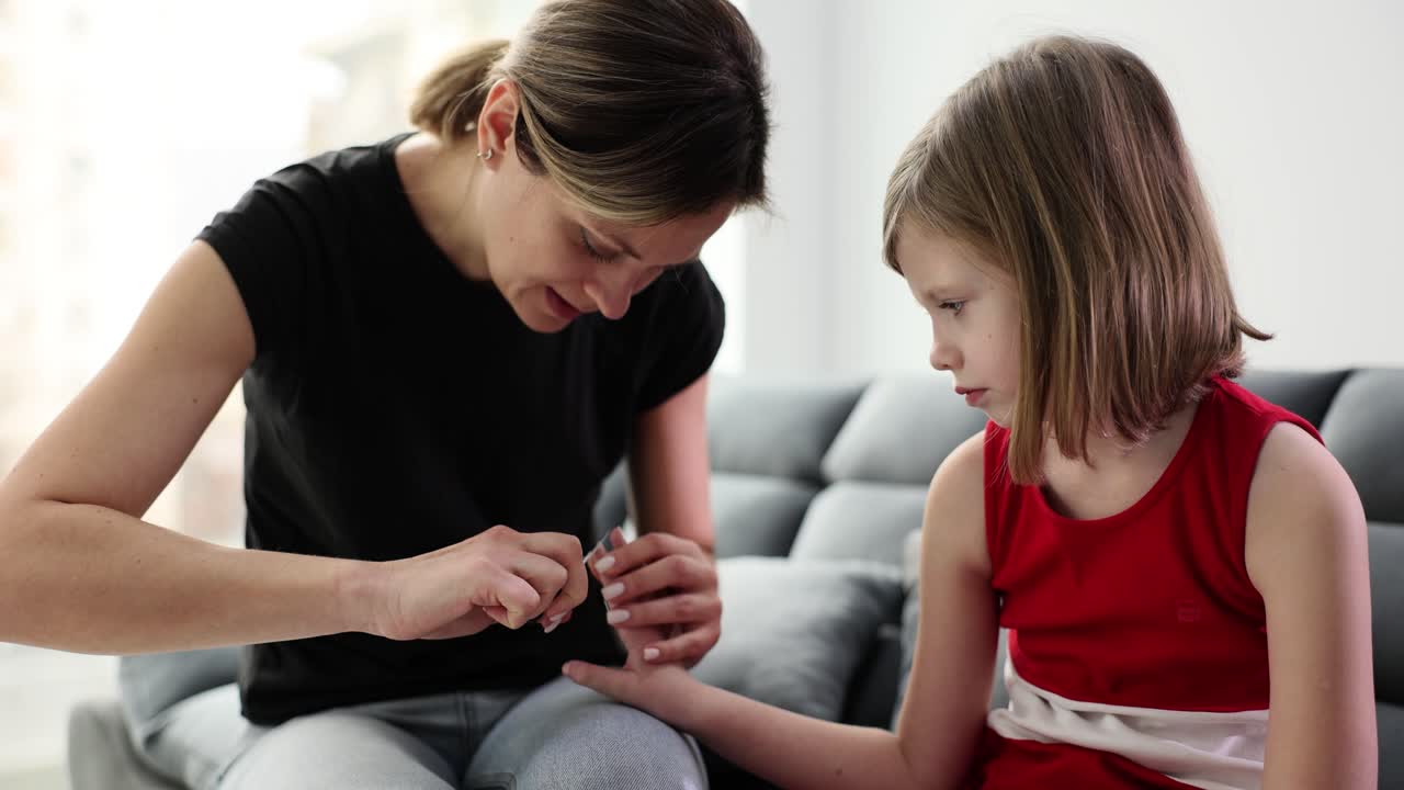 Woman cutting a child's nails