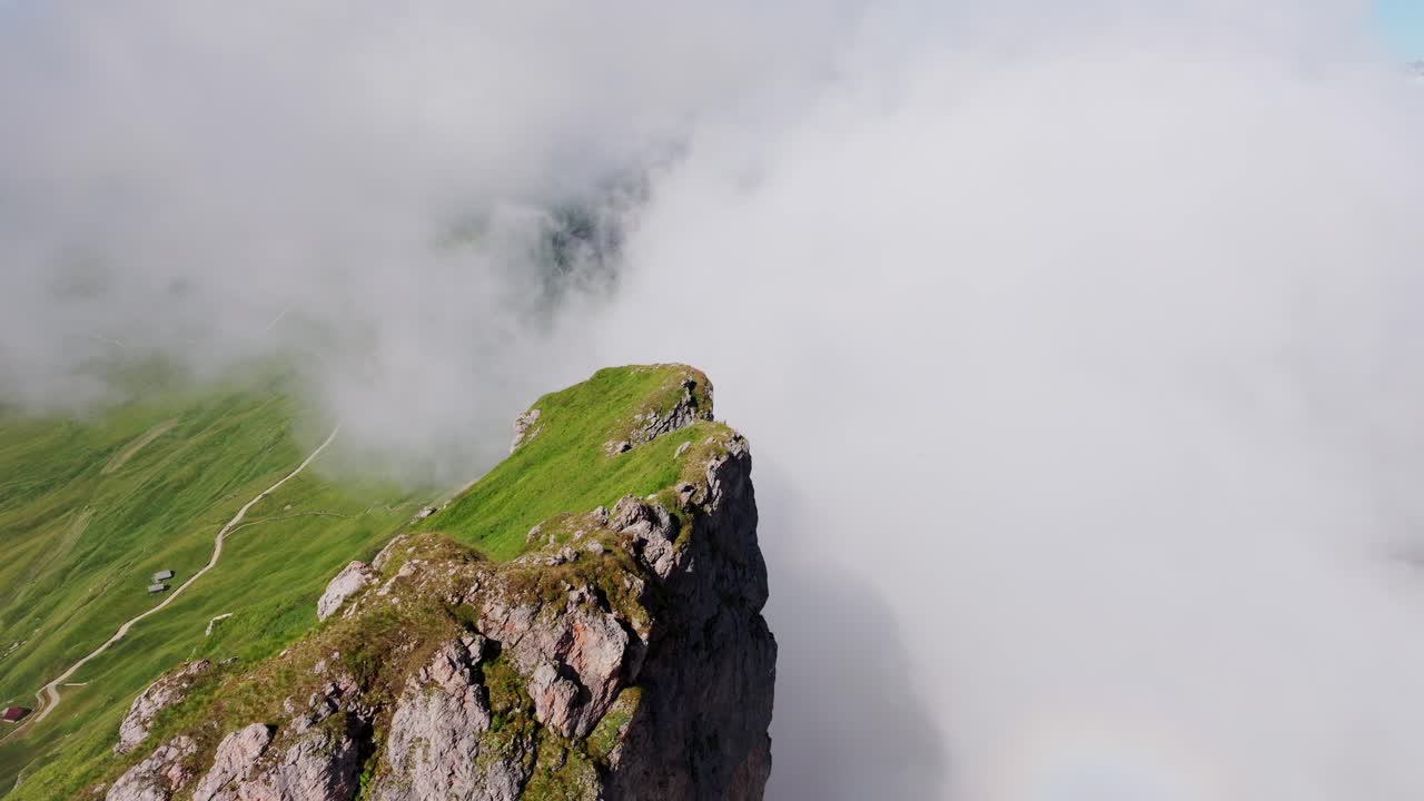 Stunning aerial perspective of Seceda’s towering cliffs rising above clouds